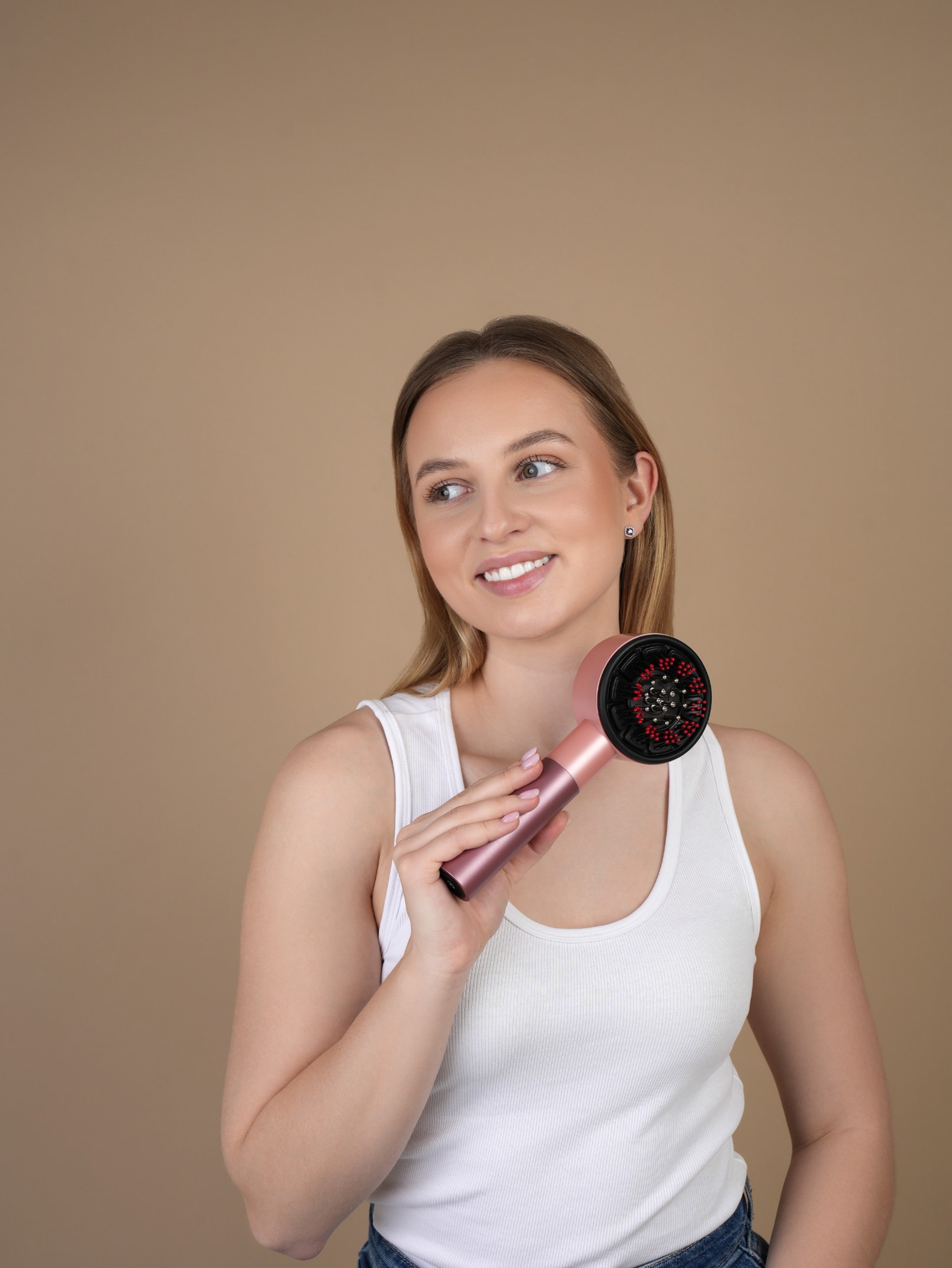 Vrouw masseert hoofdhuid met OLIEO roze scalp massager